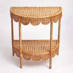 a wicker shelf with scalloped edges on the top and bottom, sitting against a white background