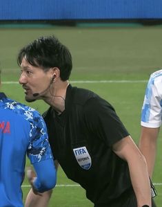 two soccer players talking to each other on the field