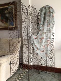 an iron gate with curtains on it in the corner of a room next to a couch