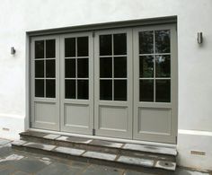 an image of a front door that is painted in gray and has three panes on each side