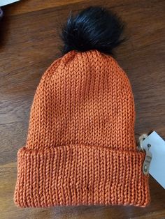 This beautiful pumpkin coloured double thickness bobble hat will keep your head nice and warm over the colder months. The hat has a black faux fur bobble that is in place by a button at the crown on the inside. This means you can remove the bobble before washing.  Once your hat is lovely and clean, you can install the hat by using a hook from the inside to pull the elastic loop through the hat and put the bobble back in place. This hat is 100% acrylic. Please wash on a gentle cycle, and dry on a very cool drying cycle. Please do not iron or use chemicals at a dry cleaners. Double Pompon Hat, Crochet Chocolate Orange Bobble Hat, Beautiful Pumpkins, Bobble Hat, Pumpkin Colors, Bobble Hats, Dry Cleaners, Handmade Hat, Black Faux Fur