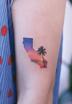 a woman's arm with a palm tree tattoo on it