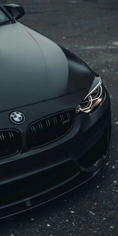 the front end of a black car parked in a parking lot