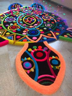 two colorful rugs on the floor with lights in the background and one has a flower design