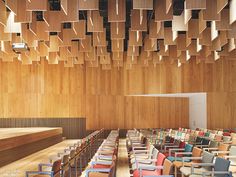 an empty auditorium with rows of chairs and wooden walls