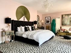 a bedroom with pink walls, black and white flooring and a bed in the middle