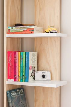 a book shelf with books and a camera