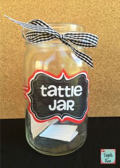 a jar with some writing on it and a bow around the top that says tattle jar