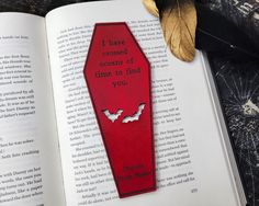 a bookmark with bats on it sitting next to an open book