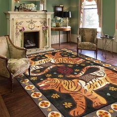 a living room filled with furniture and a rug on top of a hard wood floor