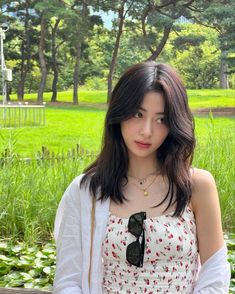 a young woman standing in front of a park