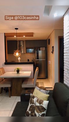 a living room and dining area in a small apartment with white tile flooring on the walls