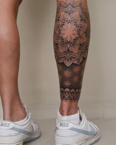 a man's leg with a tattoo on it and a flower in the middle