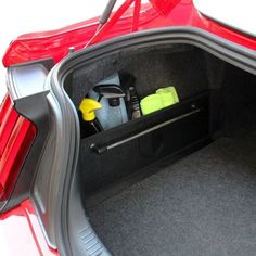 the back end of a red car with its trunk open and various items in it