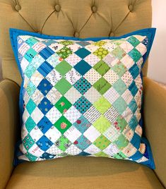 a blue and green pillow sitting on top of a chair