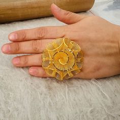 a person's hand with a gold ring on it