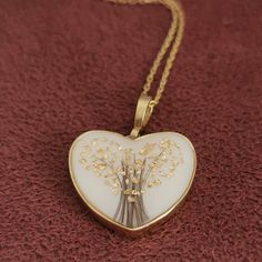 a heart shaped pendant with flowers on it