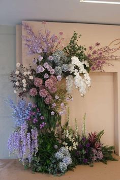 an arrangement of flowers in front of a fireplace