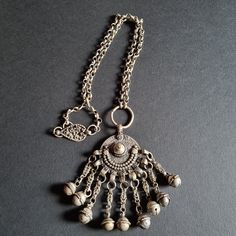 Wonderful and rare statement piece from Oman or Saudi Arabia. Made out of high grade silver this massive and ornated Maria Theresa Thaler was originally a headdress weight. It really makes a wonderful necklace both for daily use or for your unique collection. Dimension: Necklace length: 68.5 cm Pendant heigth: 9.5 cm Pendant width: 5.5 cm Weight: 98 gr. All parts are testing 800/+800/+900 Traces of Niello on both sides, dangles and clasp. Collected during mid 90s in Mutrah Souq (Oman) Dangle Necklaces With Large Pendant, Silver Necklace With Dangling Beads For Festivals, Dangle Chain Necklace For Festivals, Silver Necklaces With Dangling Beads For Festivals, Bohemian Dangle Chain Jewelry, Traditional Silver Jewelry With Chain, Antique Silver Dangle Necklaces, Silver Necklace With Dangling Beads, Traditional Silver Chain Necklace