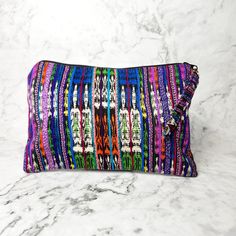 A true work of art, each Corte Cosmetic Bag is lovingly crafted on a traditional pedal loom with the same vibrant fabrics that fashion the iconic skirts of Guatemalan women. This results in an exclusive and one-of-a-kind product that will add a touch of luxury and culture to your collection. Each one has enough space to hold all of your needs, from makeup to brushes to nail polish and more! As always, Handmade and Fair Trade! 9" H x 6" W Brightly lined with nylon Zipper pull-tab 100% cotton Asso Multicolor Artisan Tote Bag, Artisan Multicolor Tote Bag, Artisan Multicolor Rectangular Bag, Multicolor Handwoven Tote Bag, Artisan Multicolor Rectangular Shoulder Bag, Multicolor Handwoven Shoulder Bag For Travel, Artisan Multicolor Handwoven Shoulder Bag, Artisan Multicolor Shoulder Bag, Artisan Multicolor Woven Shoulder Bag