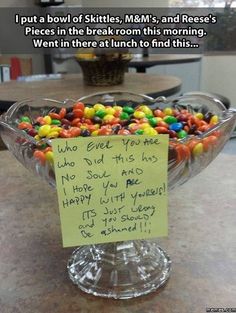 a glass bowl filled with lots of candy on top of a counter next to a sign that says, i put a bowl of skittles mem's and reese's