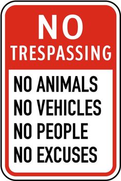 a red and white sign with the words no trespassing in black on it