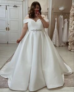 a woman is taking a selfie in her wedding dress while looking into the mirror