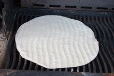 an uncooked pizza sitting on top of a grill