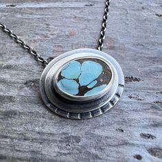 This pendant necklace is handmade from genuine turquoise and sterling silver.  The natural stone cabochon is framed by two layers of silver.  It is accented by a series of hand stamped lines.  Each unique pendant has been formed, soldered, textured, and finished entirely by hand.  I have oxidized and polished the silver to create an antique patina finish. Be sure to see all photos and video for size and color reference. Total Pendant Size: About 23x19mm The pendant is suspended from a sterling s Handmade Turquoise Necklace With Oval Pendant, Artisan Turquoise Necklace With Oval Pendant, Artisan Turquoise Oval Pendant Necklace, Artisan Turquoise Necklace With Oval Cabochon Pendant, Artisan Turquoise Cabochon Oval Pendant Necklace, Artisan Oval Turquoise Necklace One Of A Kind, One Of A Kind Oval Turquoise Artisan Necklace, Unique Oval Turquoise Cabochon Necklace, Handmade Artisan Turquoise Oval Necklace