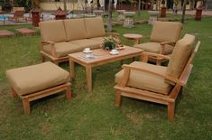 a group of wooden furniture sitting on top of a lush green field