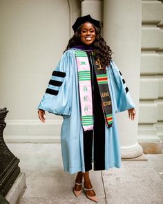 a woman wearing a blue graduation gown and hat