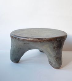 a metal stool sitting on top of a white table