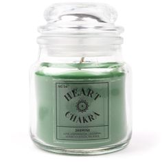 a jar filled with green candles sitting on top of a white table