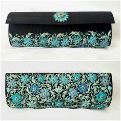 "The perfect wedding purse! A sophisticated and feminine black silk clutch bag, expertly hand embroidered by zardozi artisans. A profusion of petit blue silk flowers are inlaid with emerald gemstones. Each delicate petal and leaf is meticulously outlined with a glittery silver metallic thread, to give a sparkly, opulent 3D effect. Crowned by a beautifully embroidered blue medallion with an emerald cabochon. The word Zardozi means \"gold thread\". It is an elaborate and intricate embroidery art f Evening Clutch With Resham Embroidery Rectangular, Evening Clutch With Resham Embroidery, Traditional Floral Embroidered Clutch Evening Bag, Traditional Clutch Evening Bag With Floral Embroidery, Formal Rectangular Bag With Resham Embroidery, Elegant Floral Embroidery Potli Bag For Party, Elegant Floral Embroidered Potli Bag For Party, Festive Evening Clutch With Intricate Embroidery, Black Hand Embellished Clutch For Wedding