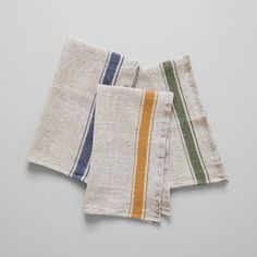 three napkins with different colored stripes on them