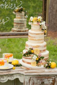 a three tiered cake sitting on top of a wooden table next to a mirror