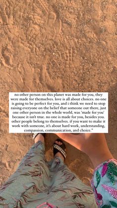 a person standing in the sand with their feet up and an open book on top of them