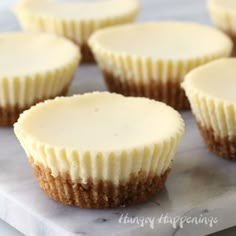 small cupcakes with white frosting sitting on a marble tray