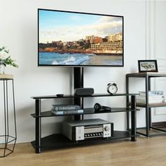 a flat screen tv sitting on top of a black shelf next to a wooden floor