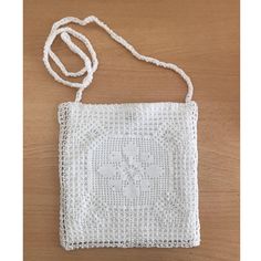 a small white bag sitting on top of a wooden table next to a string cord