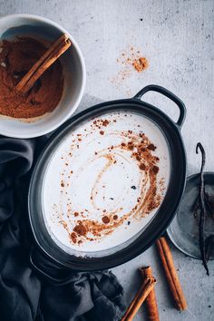 two bowls filled with cinnamon and spices on top of a table