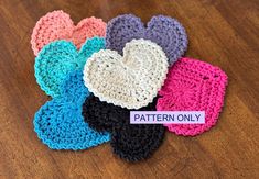 several crocheted hearts with the word pattern only written on them sitting on a wooden surface