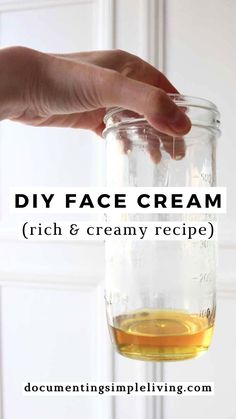 A light hand holding a glass jar with melted beeswax, shea butter, and coconut oil. Creamy Recipes