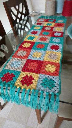 a crocheted table runner on top of a glass table