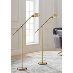 two brass - plated metal floor lamps in a living room with white carpeting