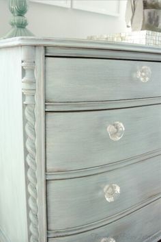 an old dresser with some knobs on it's drawers and the bottom drawer is painted blue