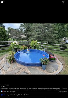 an above ground swimming pool surrounded by plants and flowers in the middle of a yard