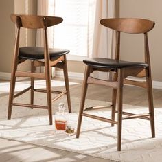 two wooden chairs sitting next to each other on top of a white carpeted floor