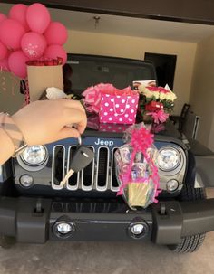 a jeep with balloons and flowers on the hood