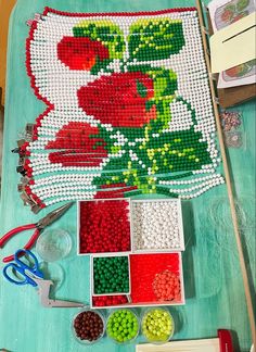 the bead work is being displayed on the table with scissors and other crafting supplies